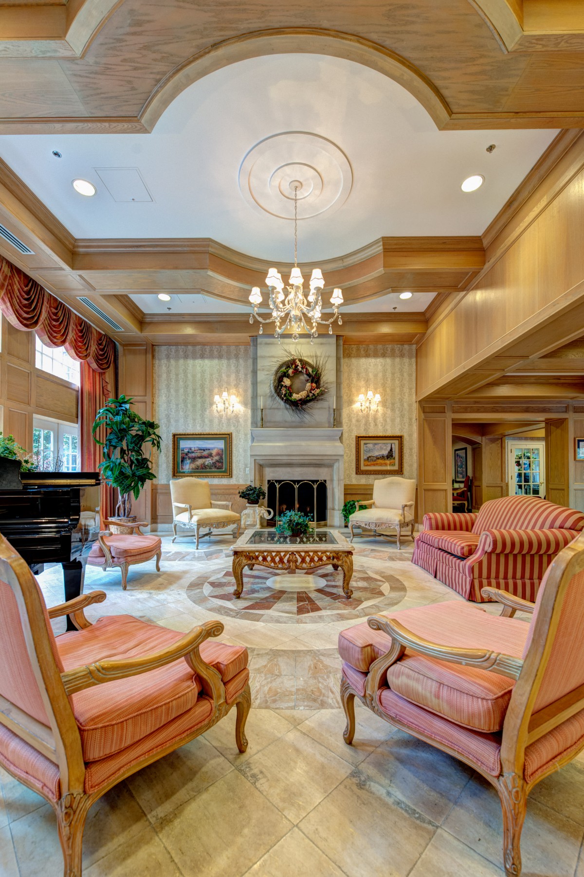 A luxurious living room with elegant furnishings, a grand piano, and a central fireplace.