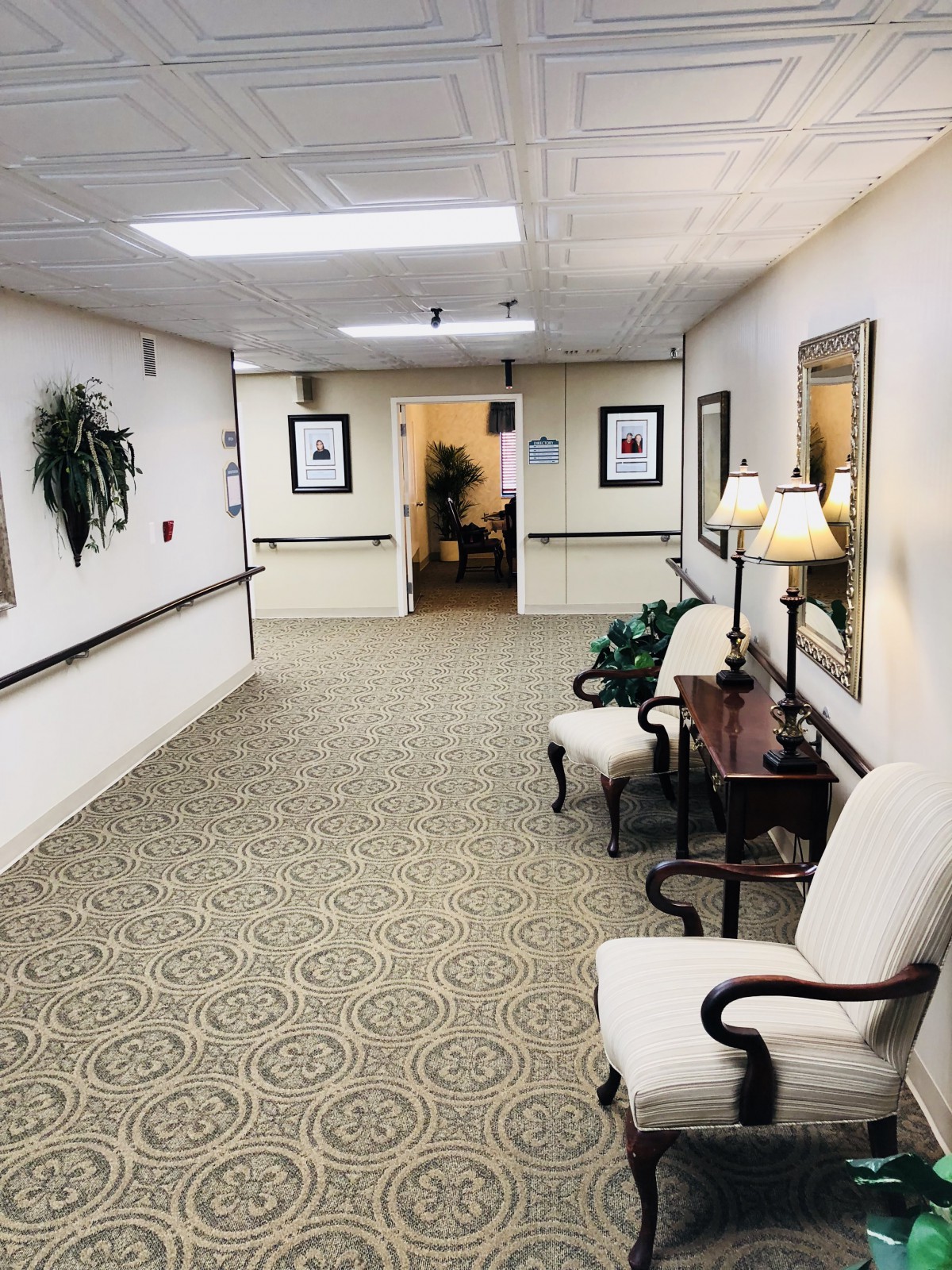 A well-decorated hallway with elegant chairs and lamps.