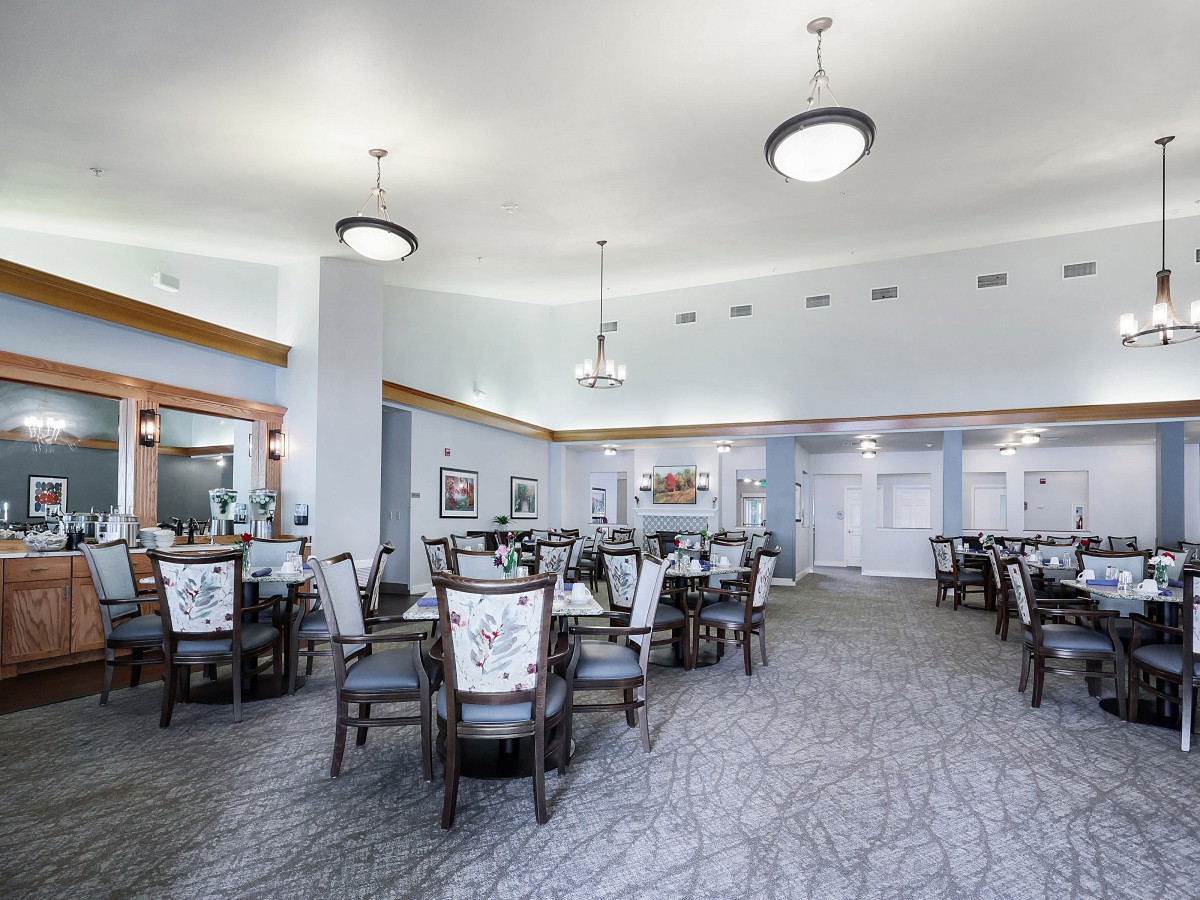 Spacious dining area with elegant furniture and chandeliers.