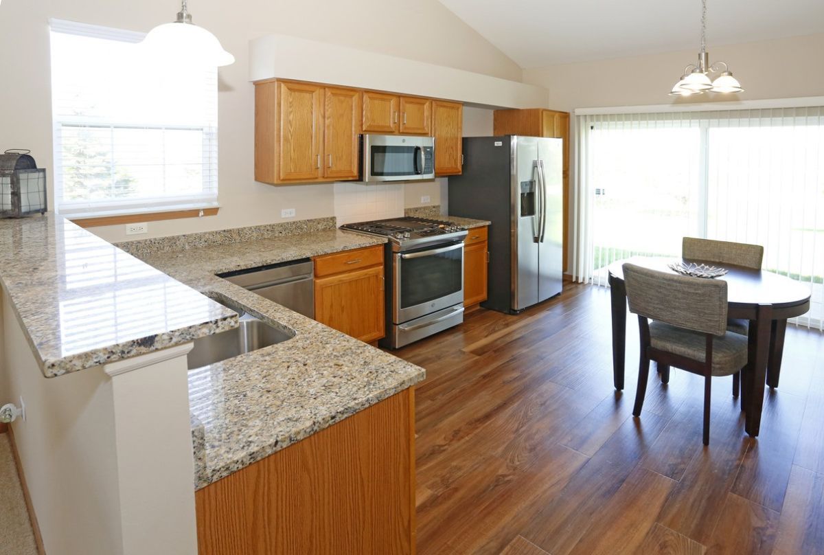 Modern kitchen with granite countertops and hardwood flooring.