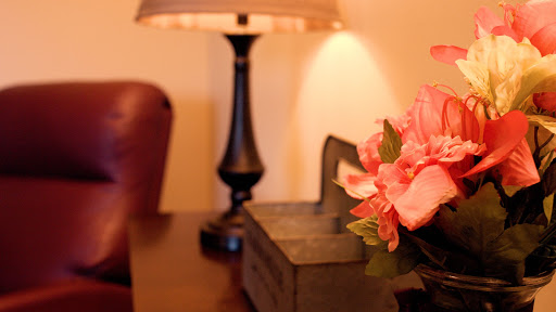 A cozy corner featuring a stylish lamp and beautiful floral arrangement.