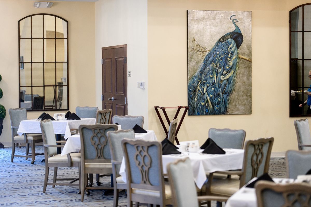 An elegant restaurant interior featuring a peacock painting on the wall.