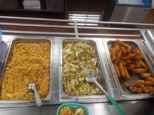 A variety of dishes available in a cafeteria setting, including rice, mixed vegetables, and fried snacks.