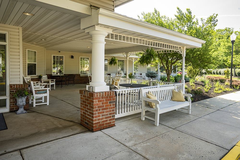 A spacious outdoor patio with white benches and a covered seating area.