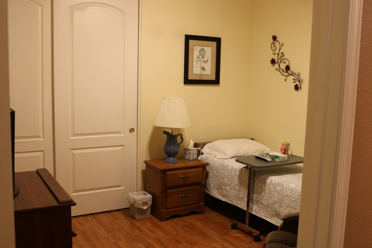 A cozy, minimalist bedroom with a single bed, nightstand, and decorative elements.