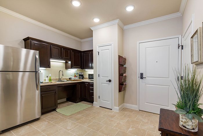 A modern kitchen with stainless steel appliances and wood cabinetry in an apartment setting.