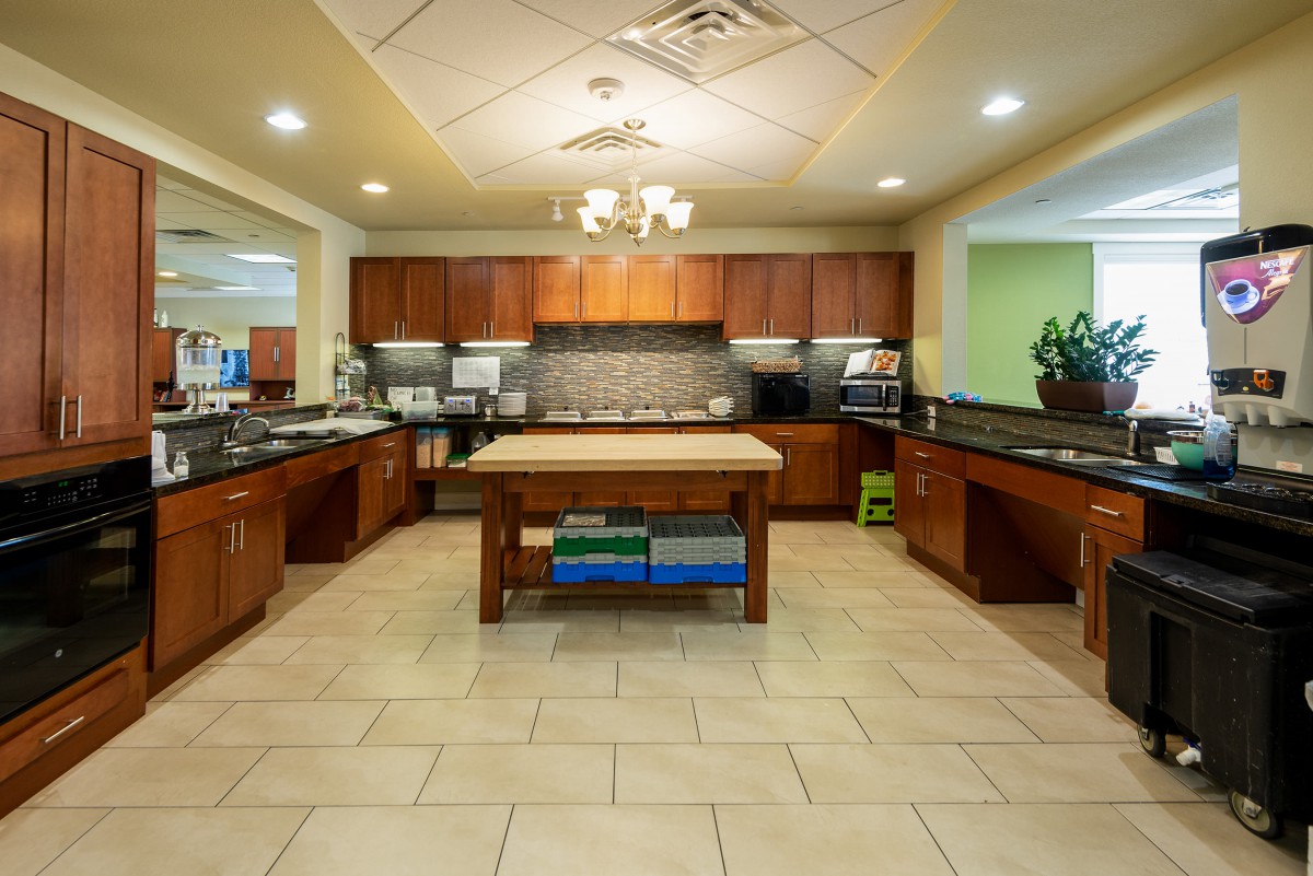 A modern kitchen interior with wood cabinets and a central island countertop.