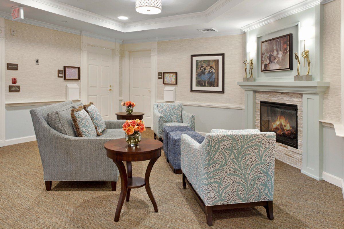 A cozy living room featuring comfortable seating, a fireplace, and floral decorations.