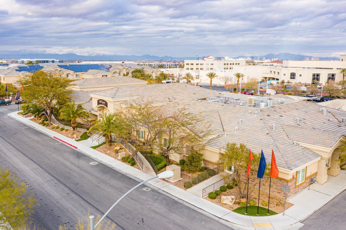 Aerial view of a suburban area with buildings, streets, and flags on a cloudy day.