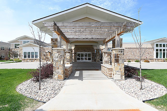 A modern building entrance with stone pillars and a covered pathway.