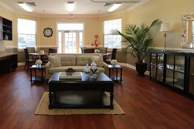 A cozy living room with a sofa and coffee table, complemented by plants and elegant decor.