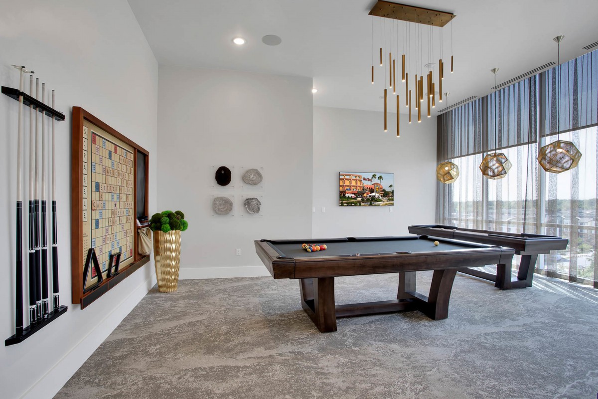 A stylish game room featuring a pool table and modern decor elements.