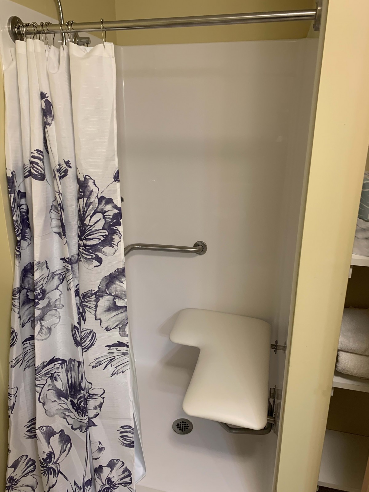 An accessible shower with a seat and grab bar.