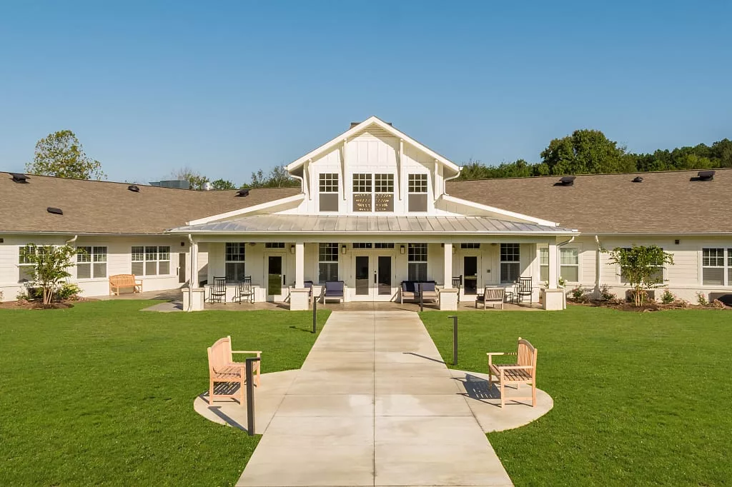 A modern building with a well-maintained lawn and pathway leading to the entrance.