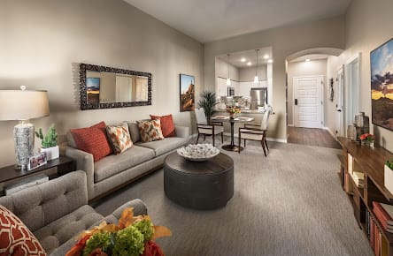 A cozy living room with neutral tones featuring a comfortable sofa, coffee table, and an adjacent dining area.