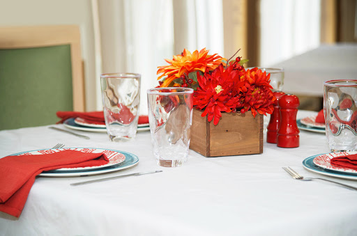 A beautifully arranged dining table featuring vibrant flowers and elegant place settings.