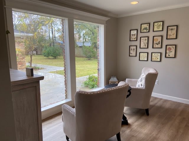 A cozy living room with two chairs facing a large window, offering a pleasant view of the outdoors.