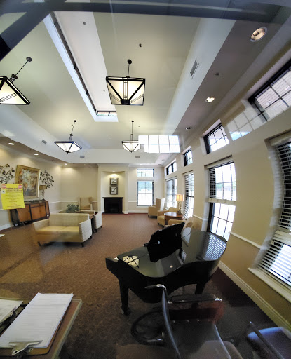 A cozy lobby space featuring elegant furniture and a grand piano, illuminated by stylish lighting.