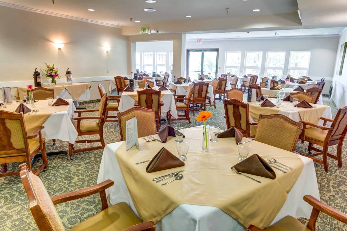 Elegant dining area with neatly set tables and chairs.