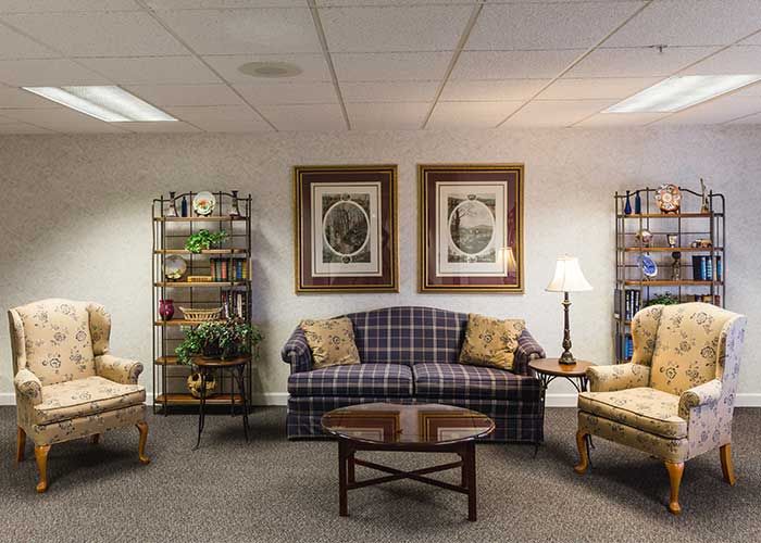 A cozy living room with a plaid sofa, two armchairs, and a wooden coffee table.