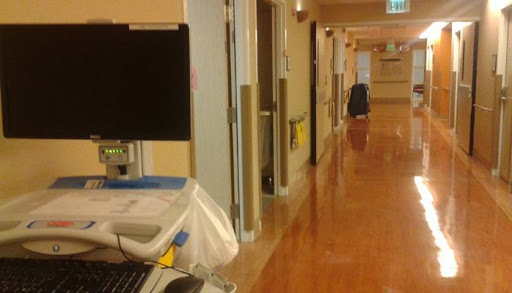 A quiet corridor in a hospital, showcasing medical equipment and patient rooms.