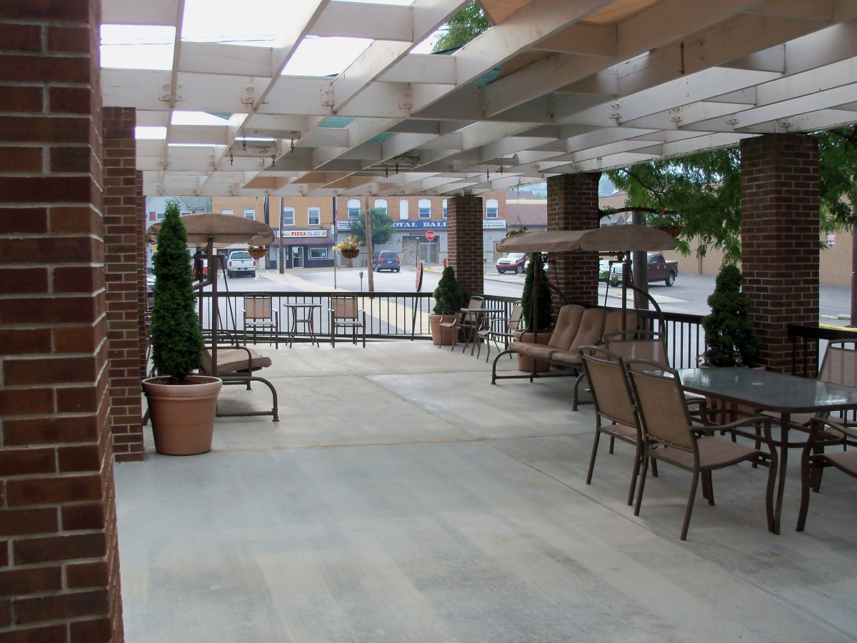 A covered outdoor patio with seating and potted plants.