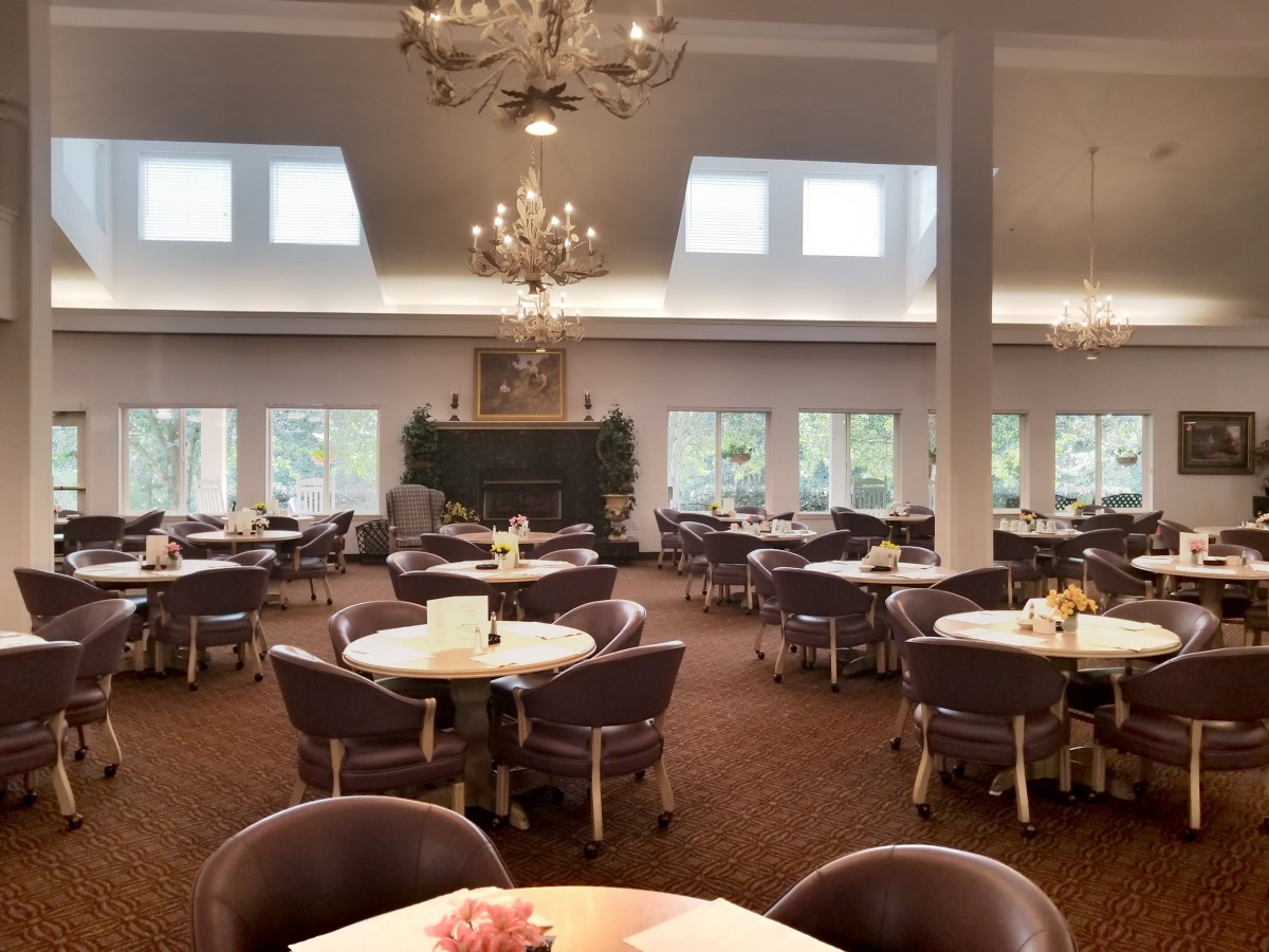 Elegant dining area with round tables and chandeliers.