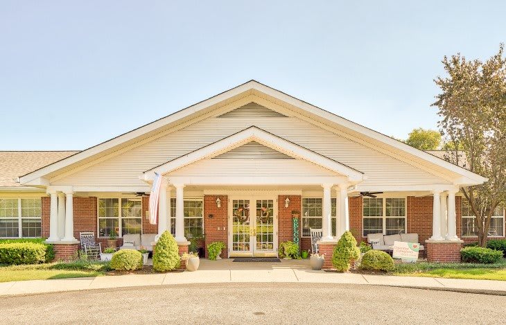 A suburban house with a welcoming front porch and tidy landscaping.