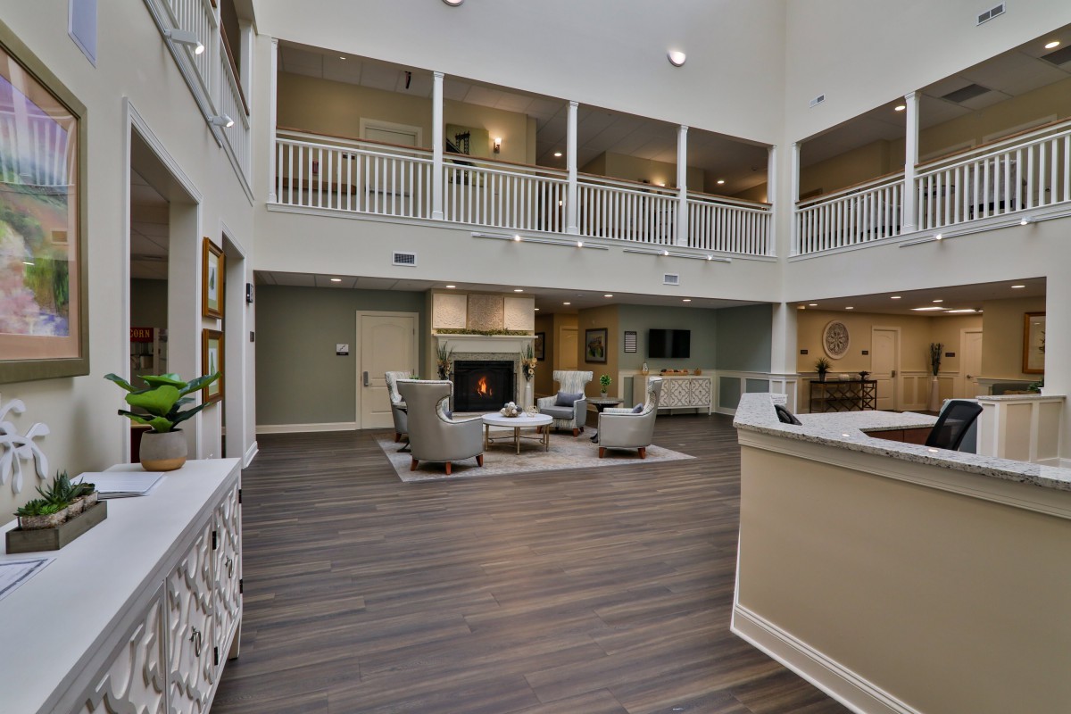 Spacious lobby area with modern furniture and a central fireplace.
