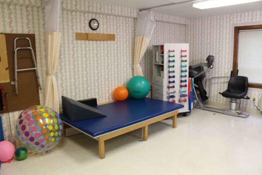 A physical therapy room equipped with exercise tools and treatment tables.