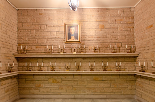 A serene wall adorned with candles and a portrait, creating a peaceful atmosphere.