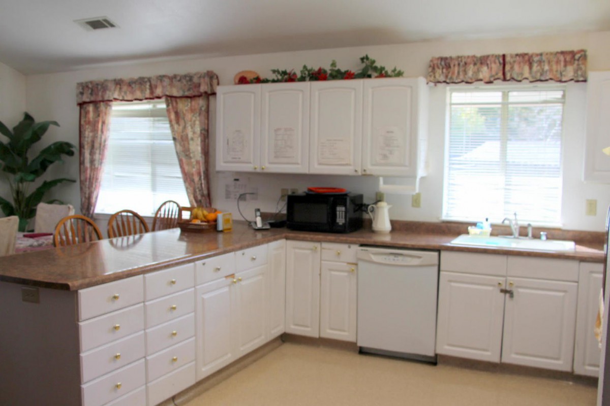 A cozy kitchen with white cabinets and a microwave on the countertop.