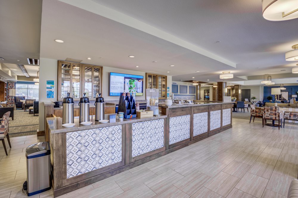 Modern hotel lobby with a welcoming reception desk and coffee station.