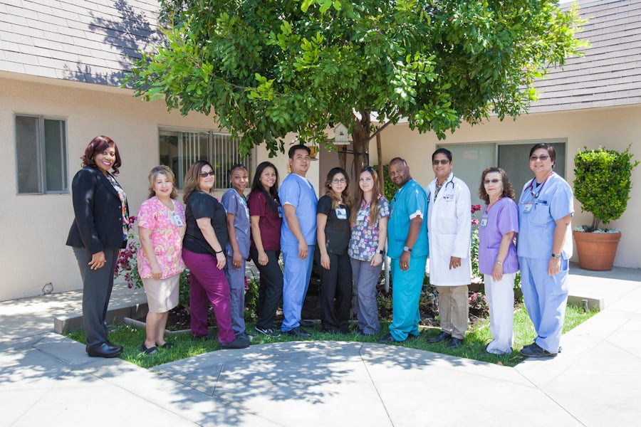 A group of healthcare professionals standing outside in front of a building.