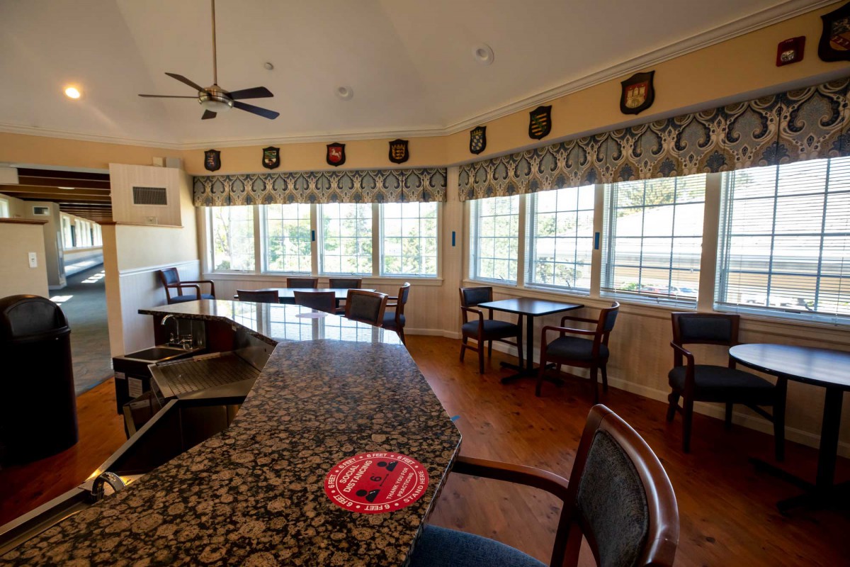 A cozy bar area with large windows and seating arrangements.