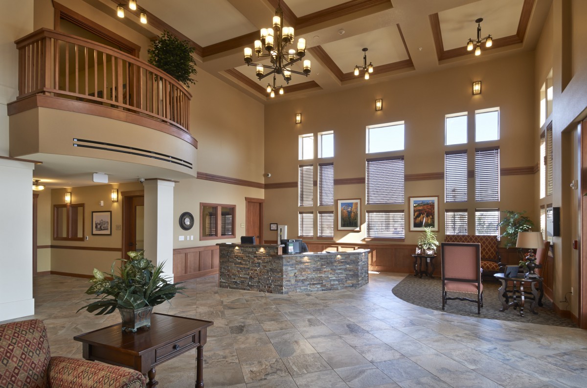 A spacious and elegantly designed lobby with large windows, a reception area, and stylish chandeliers.