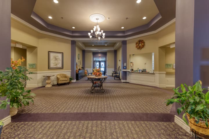 A spacious and elegantly decorated lobby featuring a chandelier and comfortable seating.