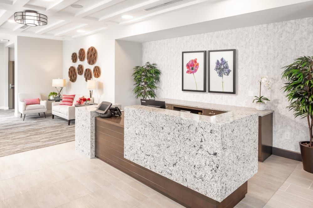 A modern office reception area with a stylish desk and decorative artwork on the walls.