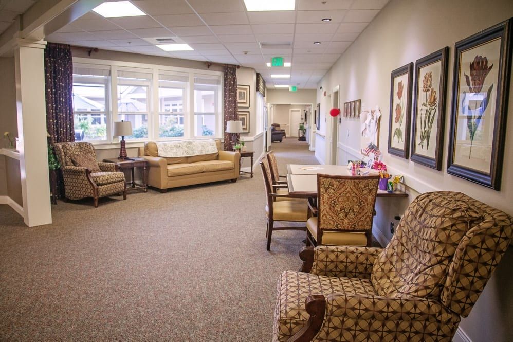 A cozy seating area with sofas and chairs in a well-lit hallway.