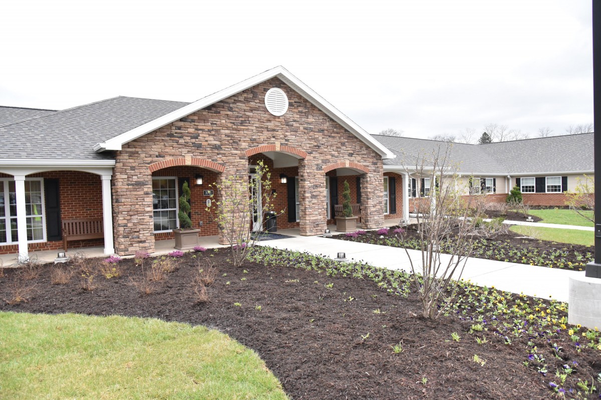 A brick building with a landscaped front yard and walkway.