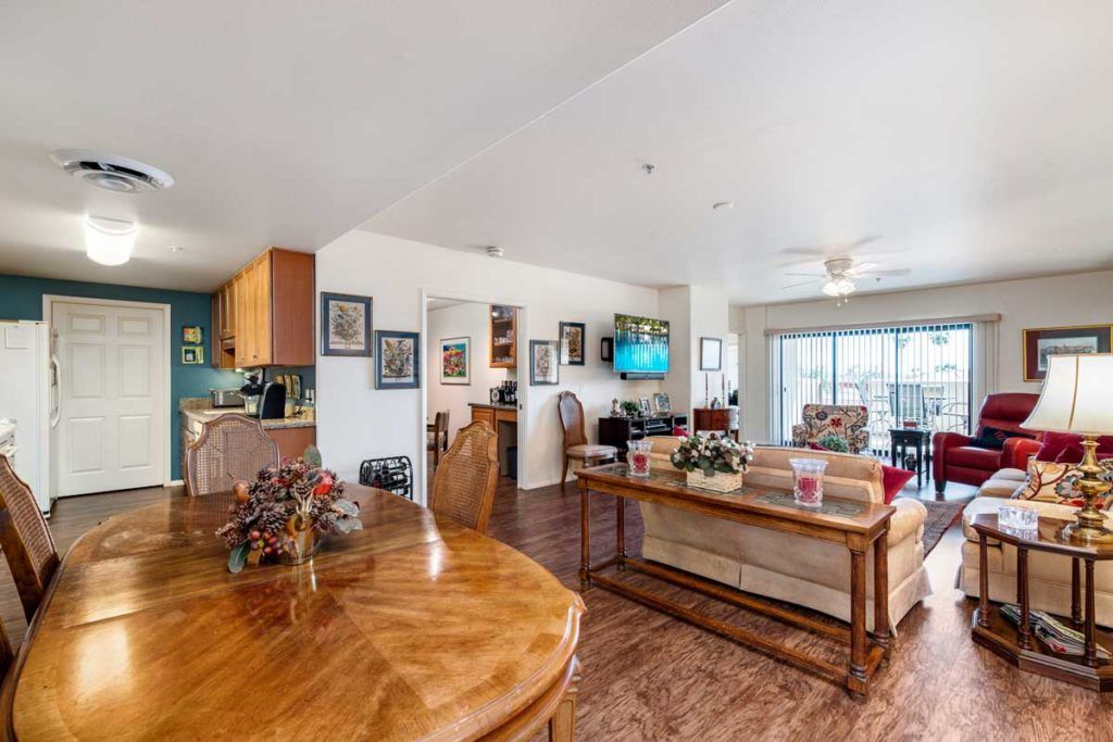 A cozy open floor plan living space with a view of the kitchen, dining area, and comfortable seating.