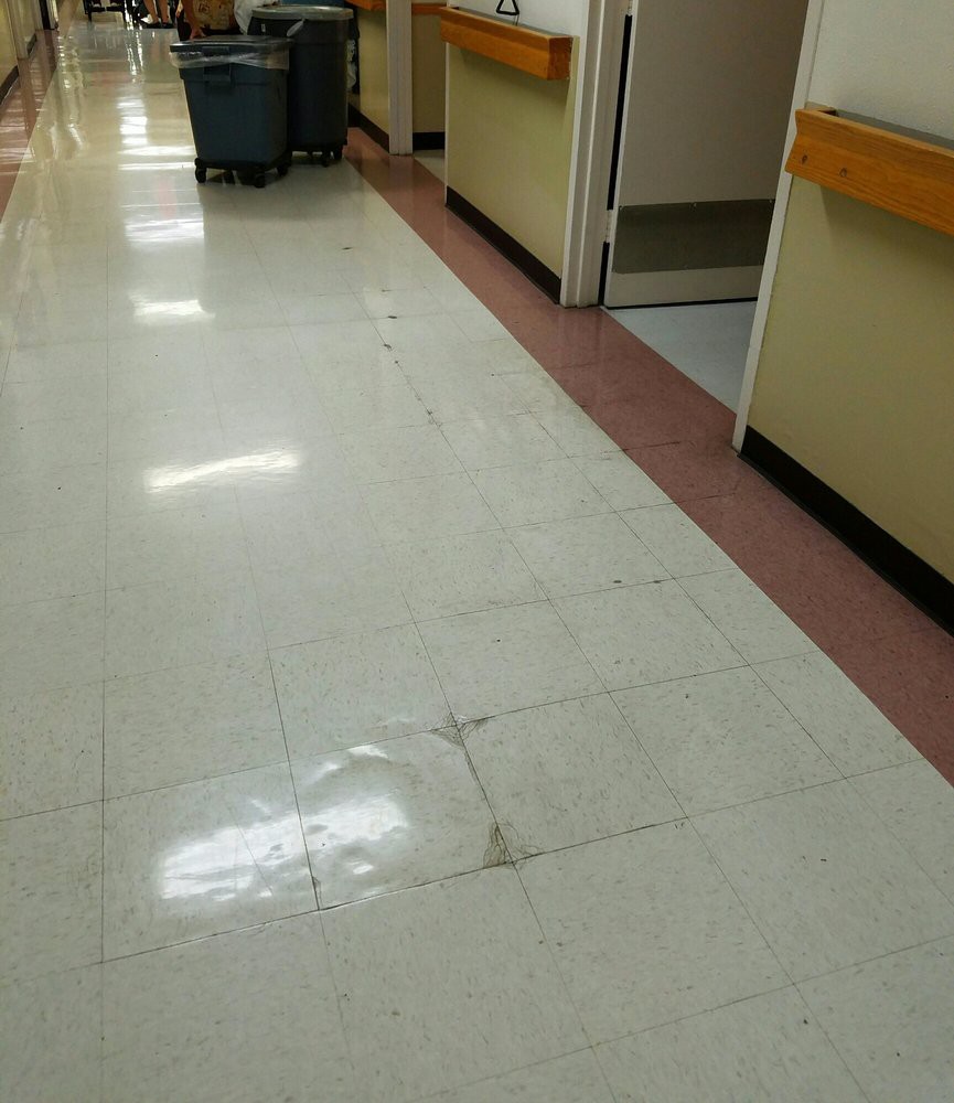 A hospital corridor with clean, tiled flooring.
