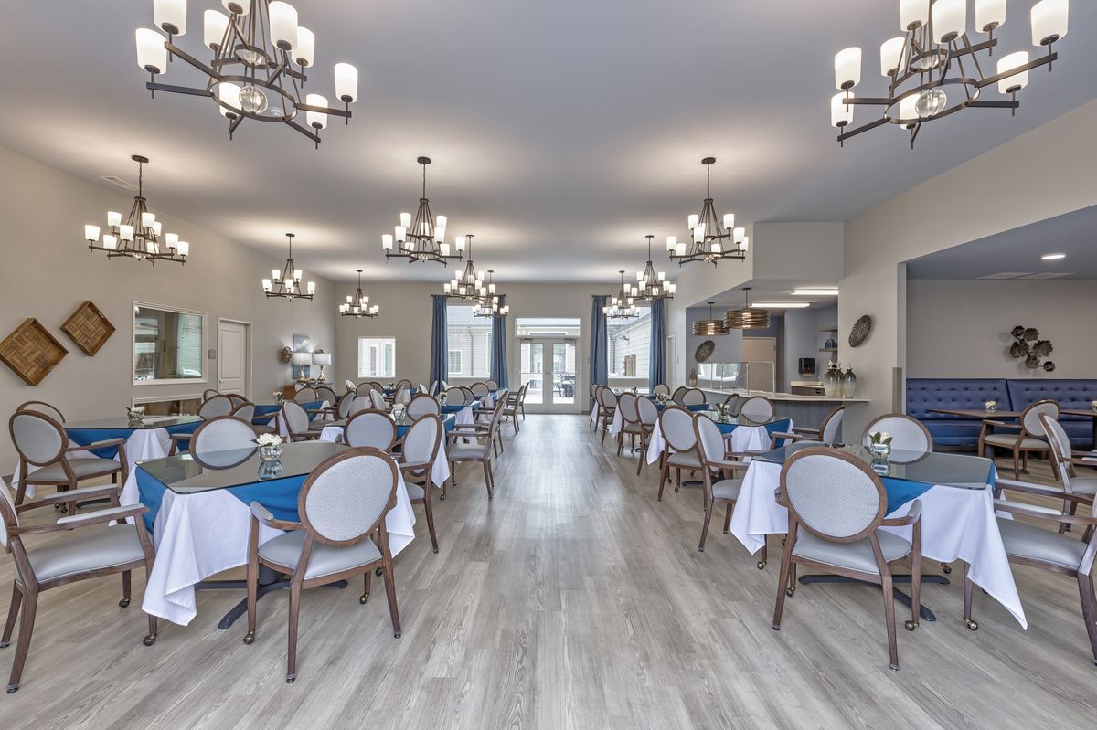 Spacious dining area with elegant chandeliers and neatly arranged tables.