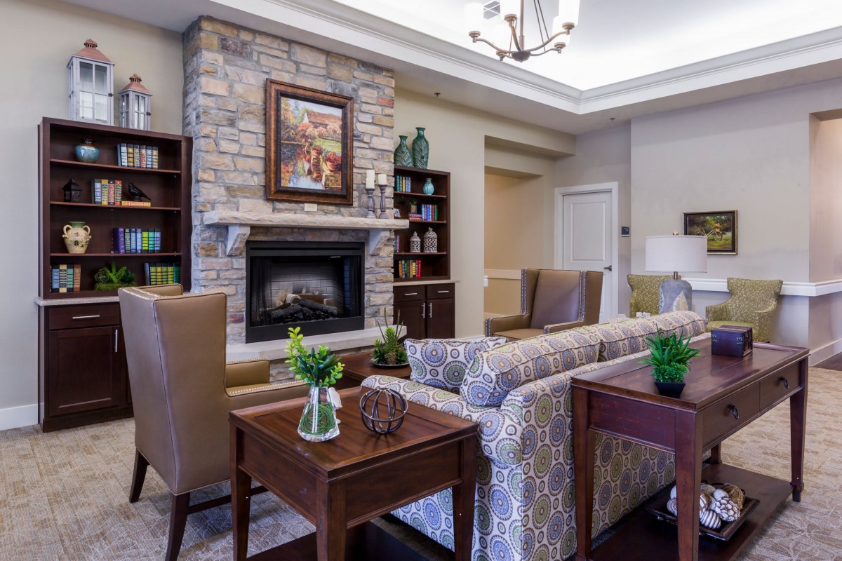 A cozy living room with a stone fireplace, elegant furniture, and tasteful decor.