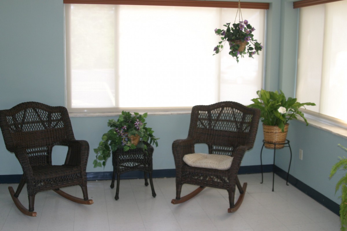 A cozy living space featuring rocking chairs and indoor plants by a large window.
