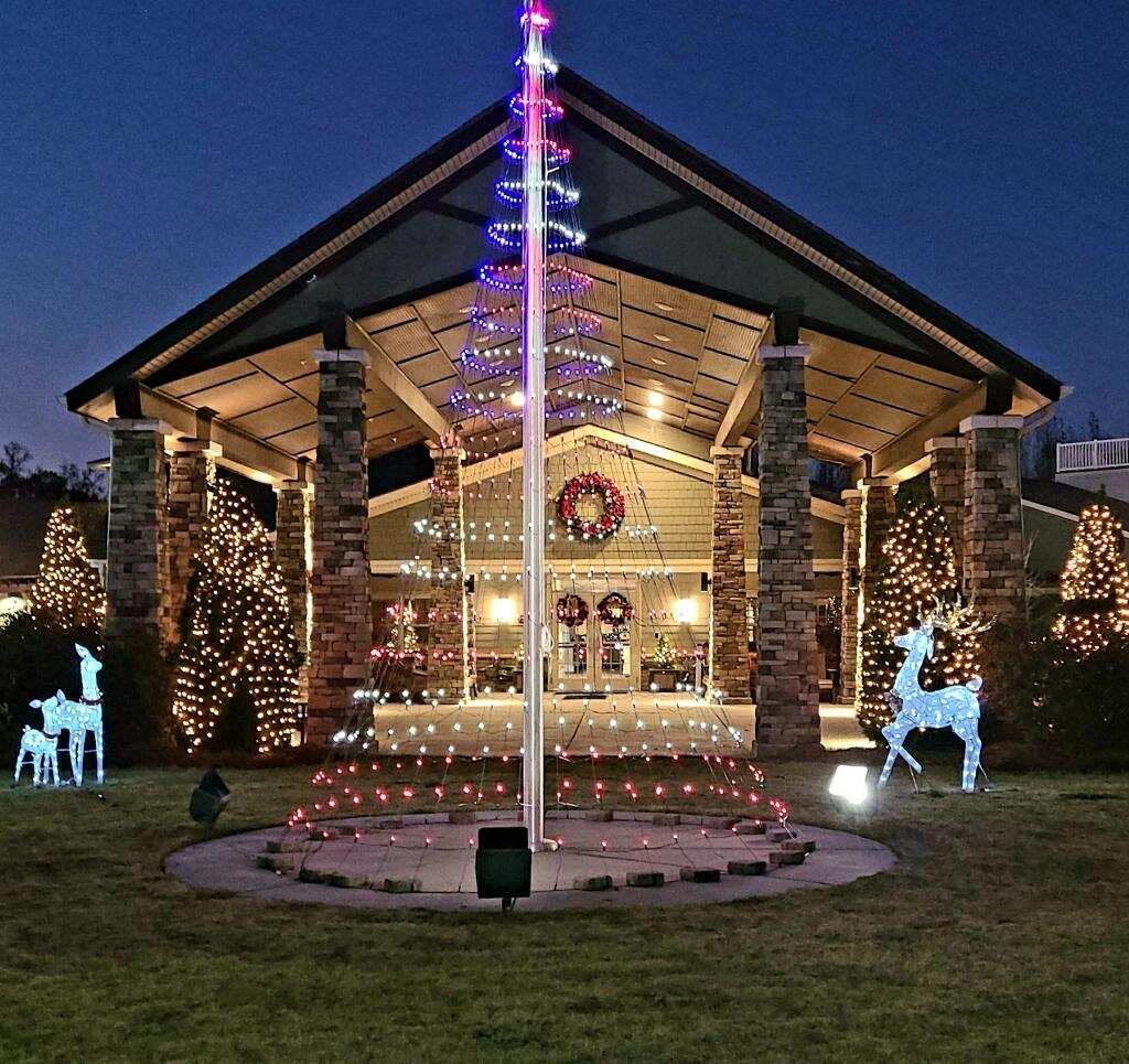 A beautifully decorated house adorned with festive Christmas lights and reindeer figures, creating a warm holiday atmosphere in the evening.