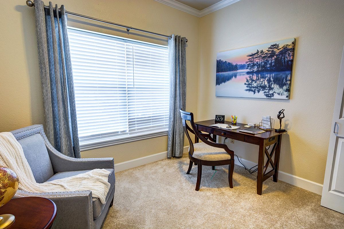 A cozy home office with a desk and chair by the window.