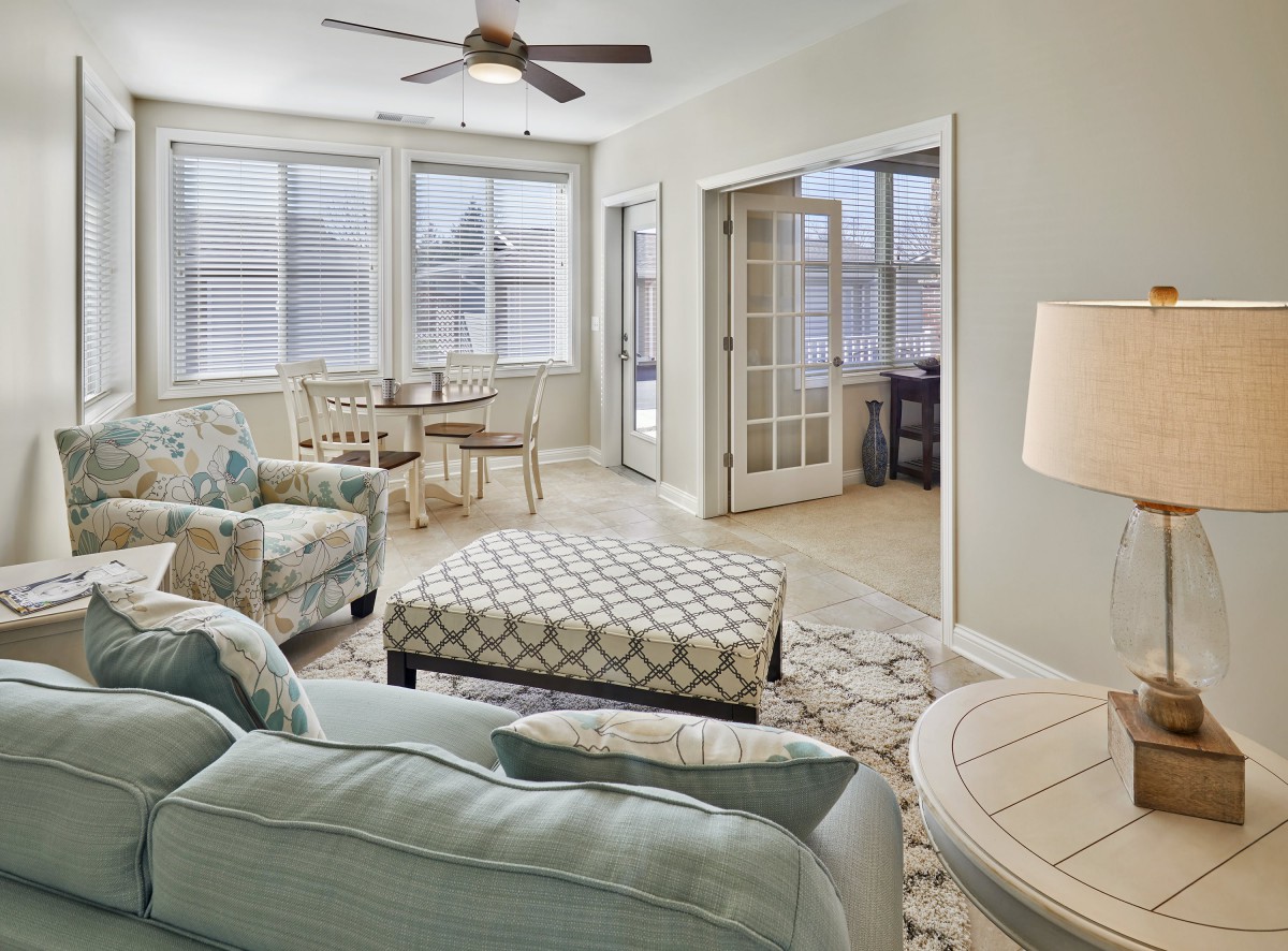 A cozy living room with pastel-colored furniture and an adjoining dining area.