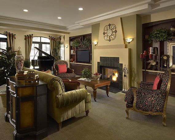 A cozy and traditionally decorated living room featuring a fireplace and a grand piano.