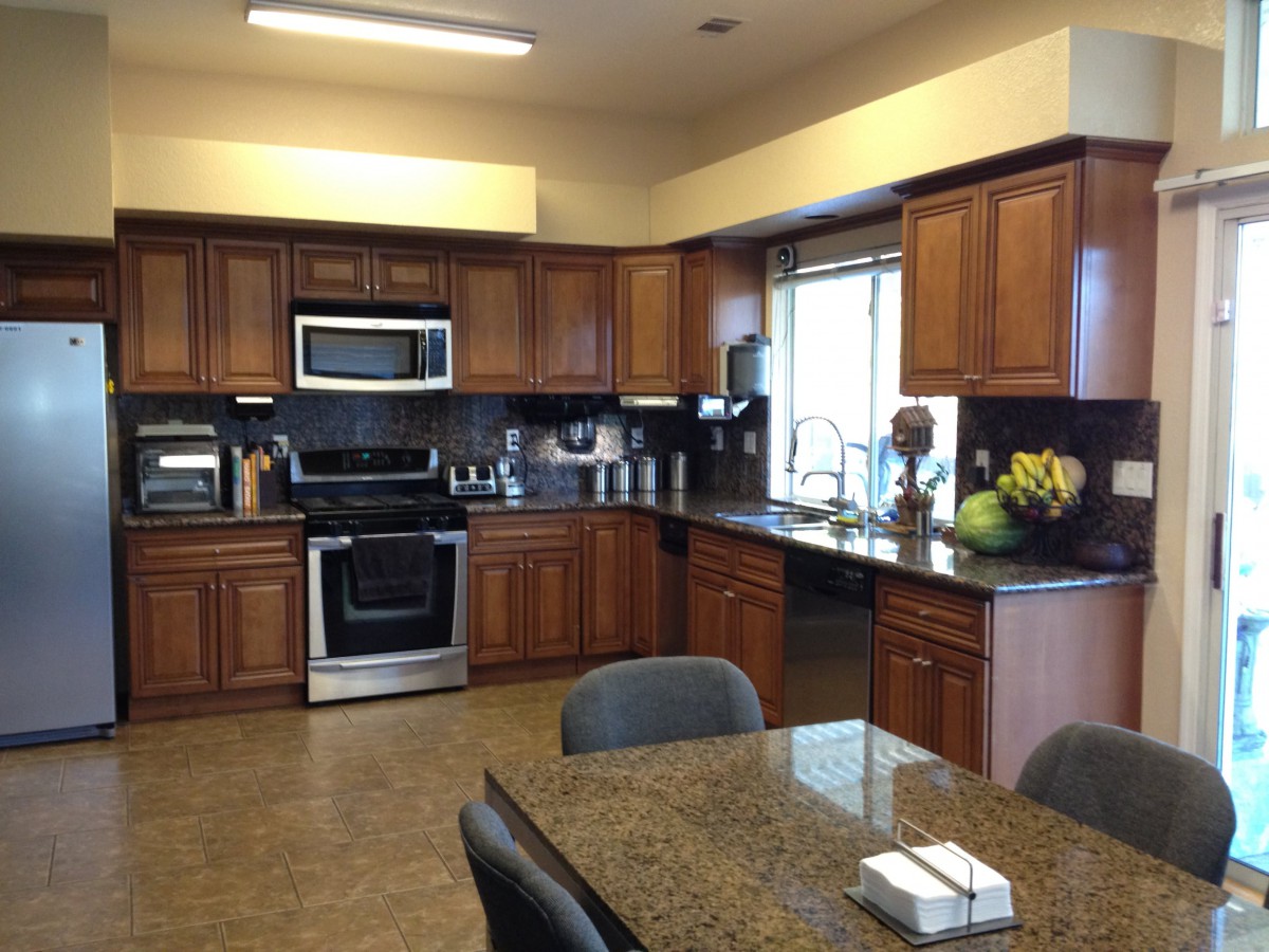 Spacious kitchen with wooden cabinets and stainless steel appliances.